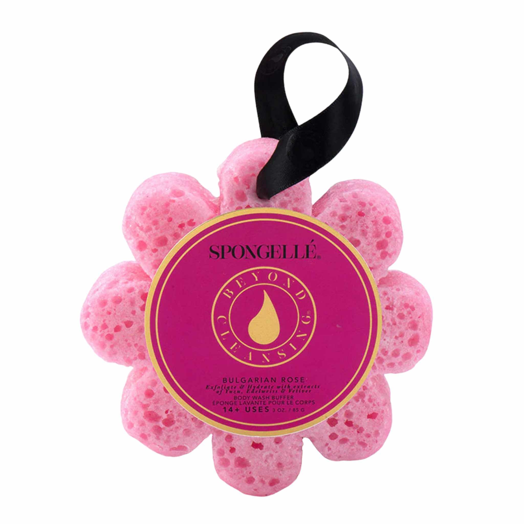 A flower-shaped bath sponge with a pink texture and a black ribbon, branded by Spongellé, with a label indicating the fragrance as Bulgarian Rose.