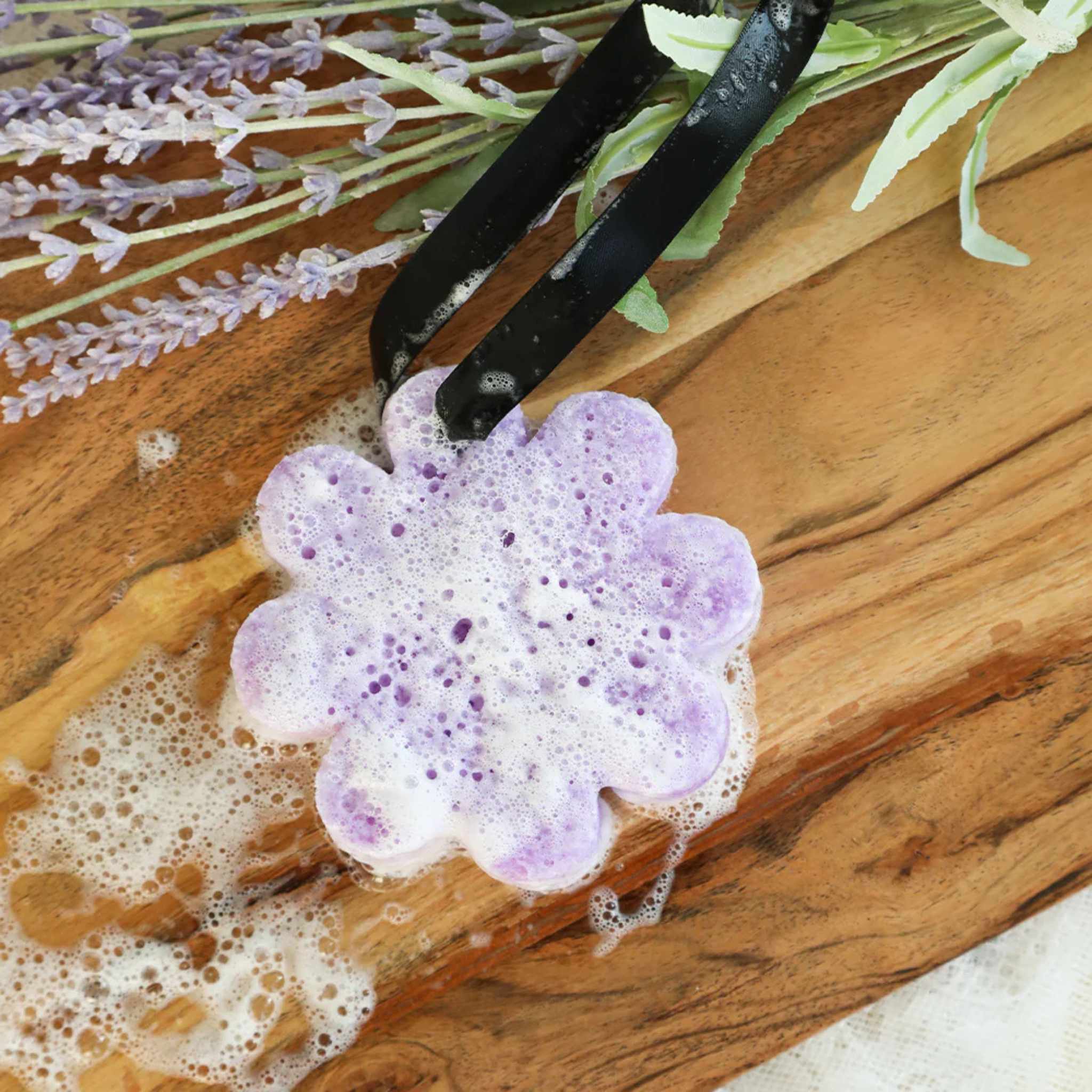 Soapy sponge on wooden background