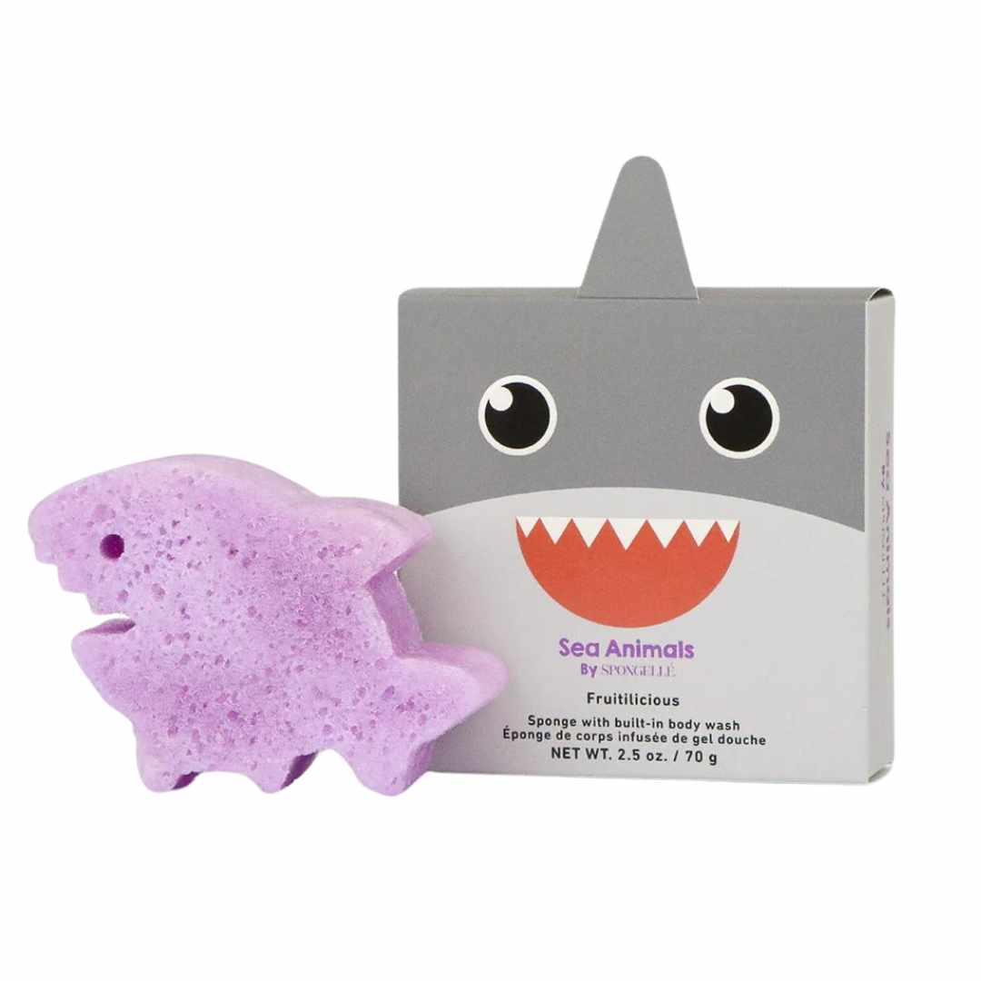 A purple bath sponge designed to look like a shark, with a packaging box that has &