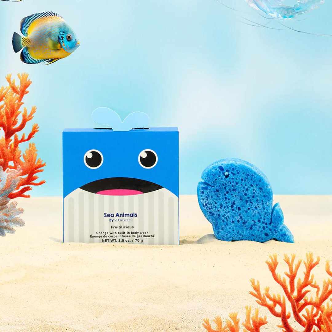 A blue sponge in the shape of a whale with a friendly facial expression, next to its packaging box labeled &