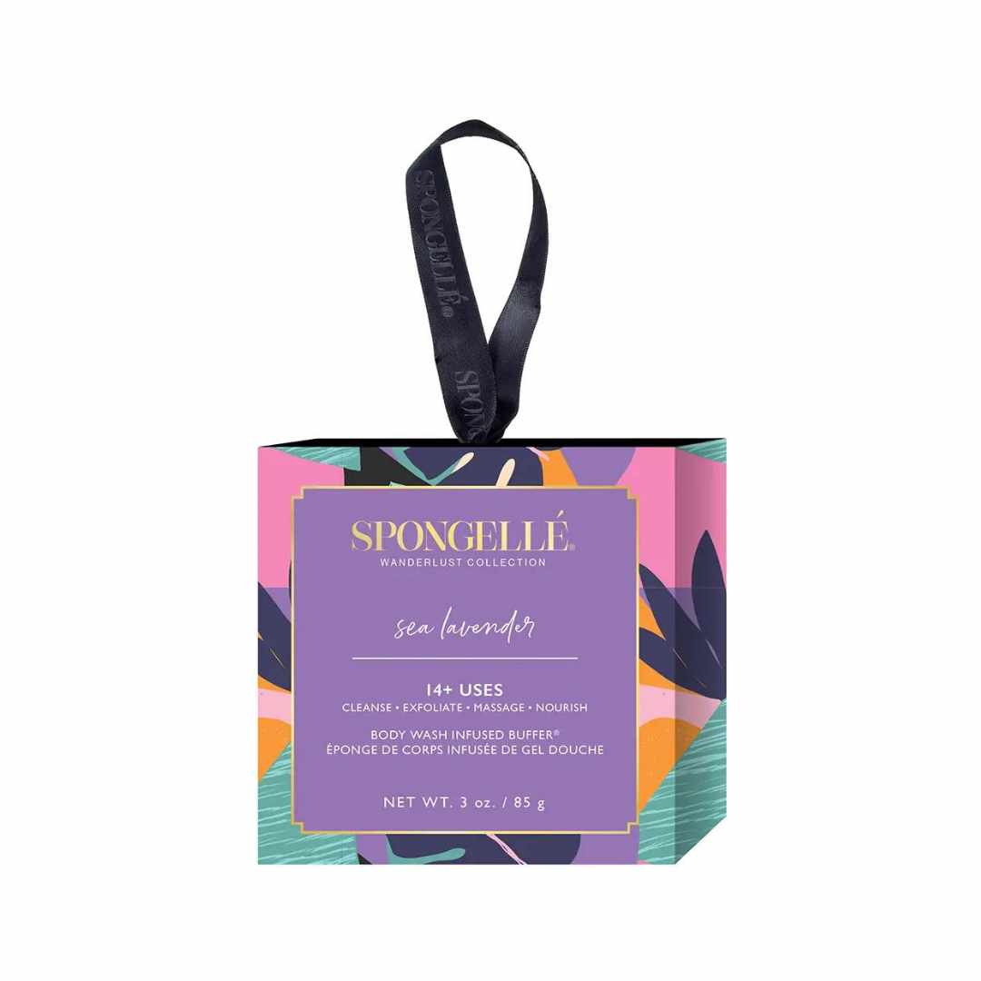 A box of Spongellé Wanderlust Collection body wash infused buffers with a Sea Lavender fragrance theme. The packaging is vibrant with multicolored patterns and the Spongellé brand is visible.
