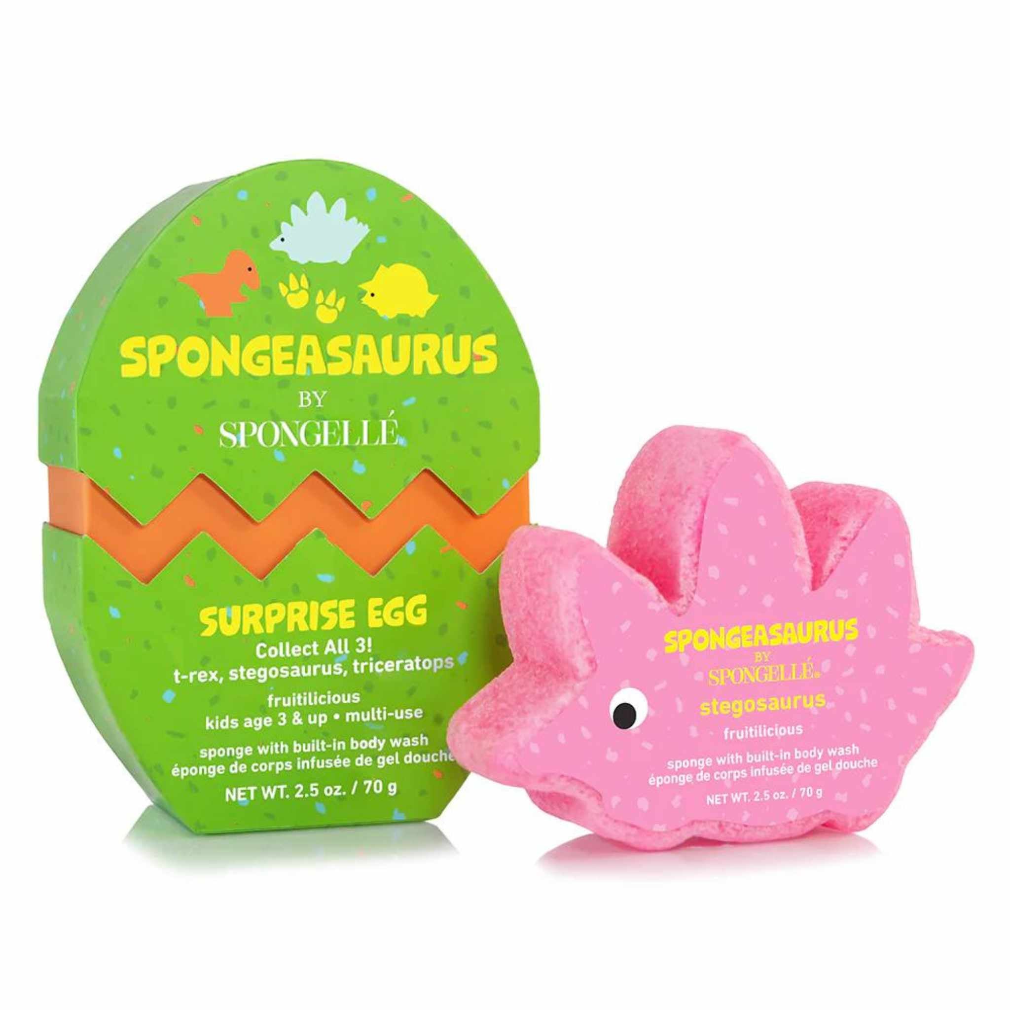 A pink sponge designed to look like a Stegosaurus dinosaur, packaged in a green and orange egg-shaped container with &