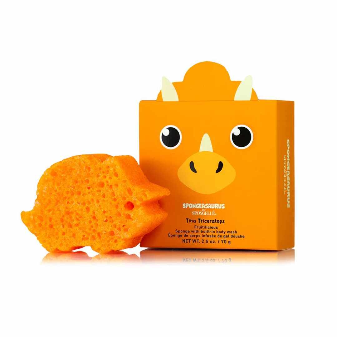 An orange sponge with a dinosaur face design, named Tina Triceratops, from the Spongellé Spongeasaurus Collection, with a surprise Dino egg packaging.