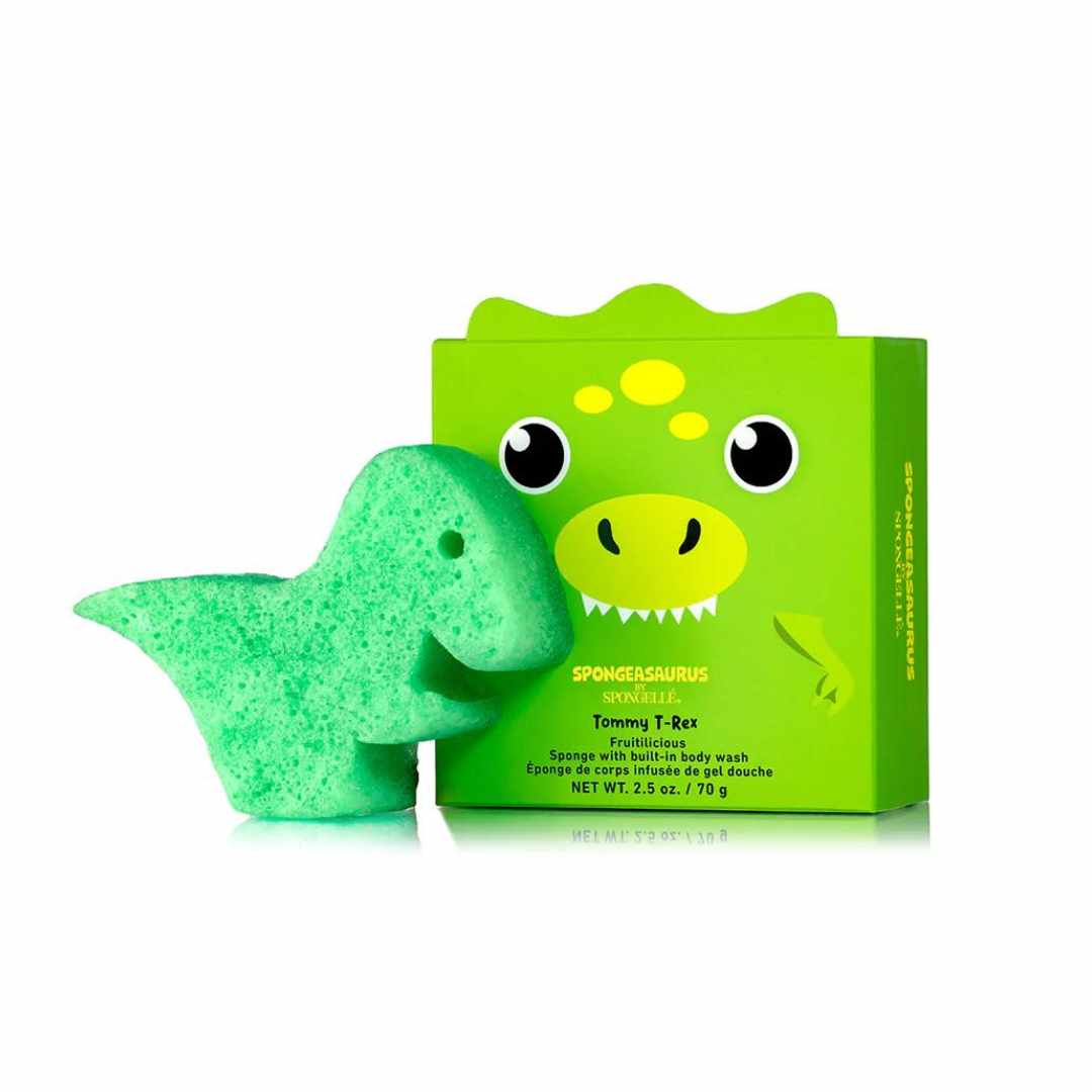 A green sponge shaped like a dinosaur (specifically a T-rex) next to its packaging box with &