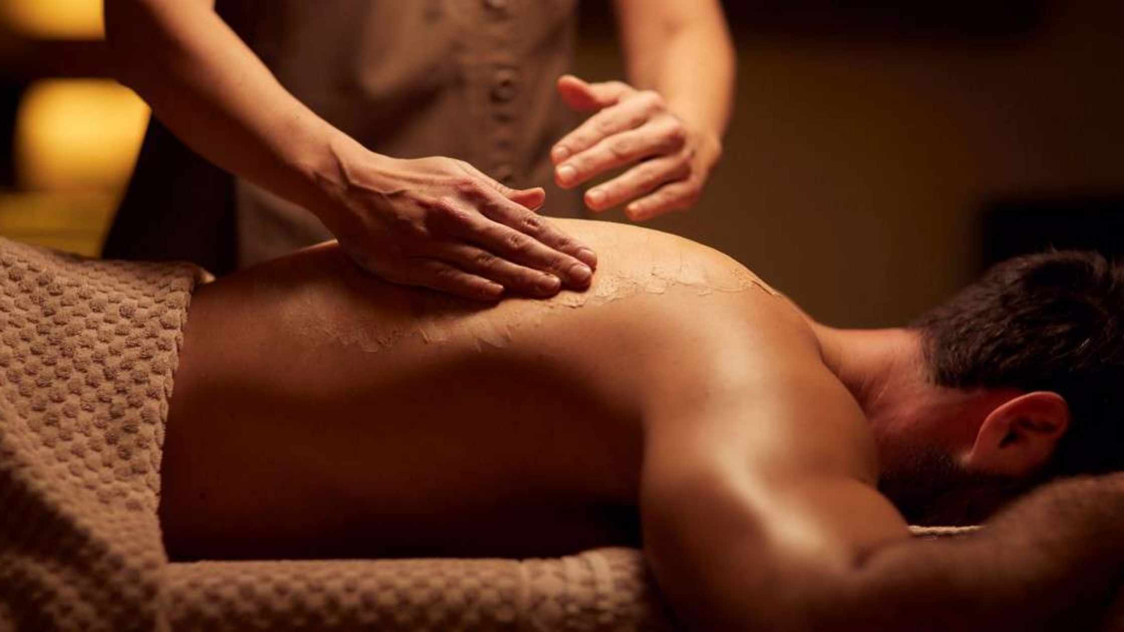 A man laying down on his front and receiving an ELEMIS massage