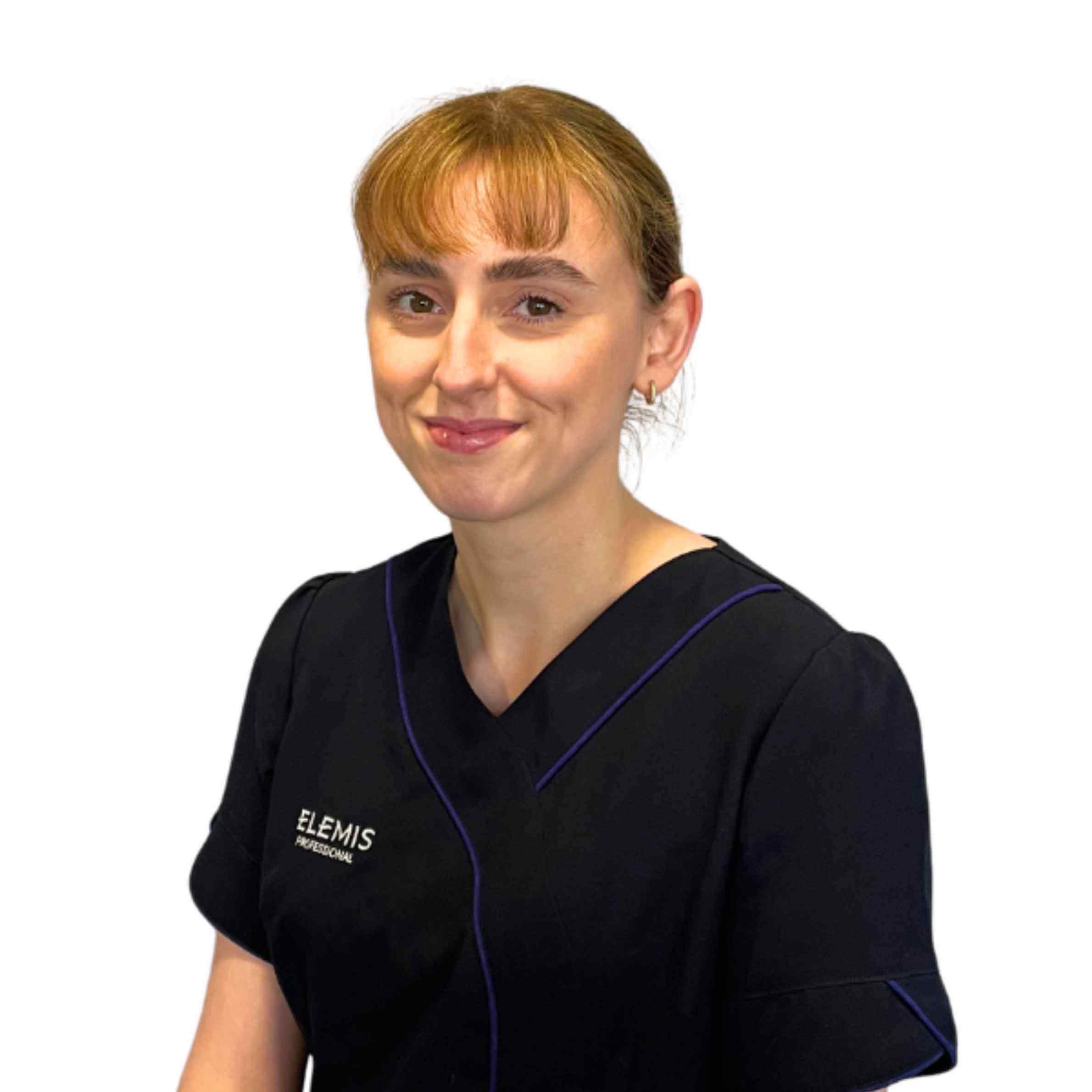 Woman wearing a black Elemis scrub top on a white background