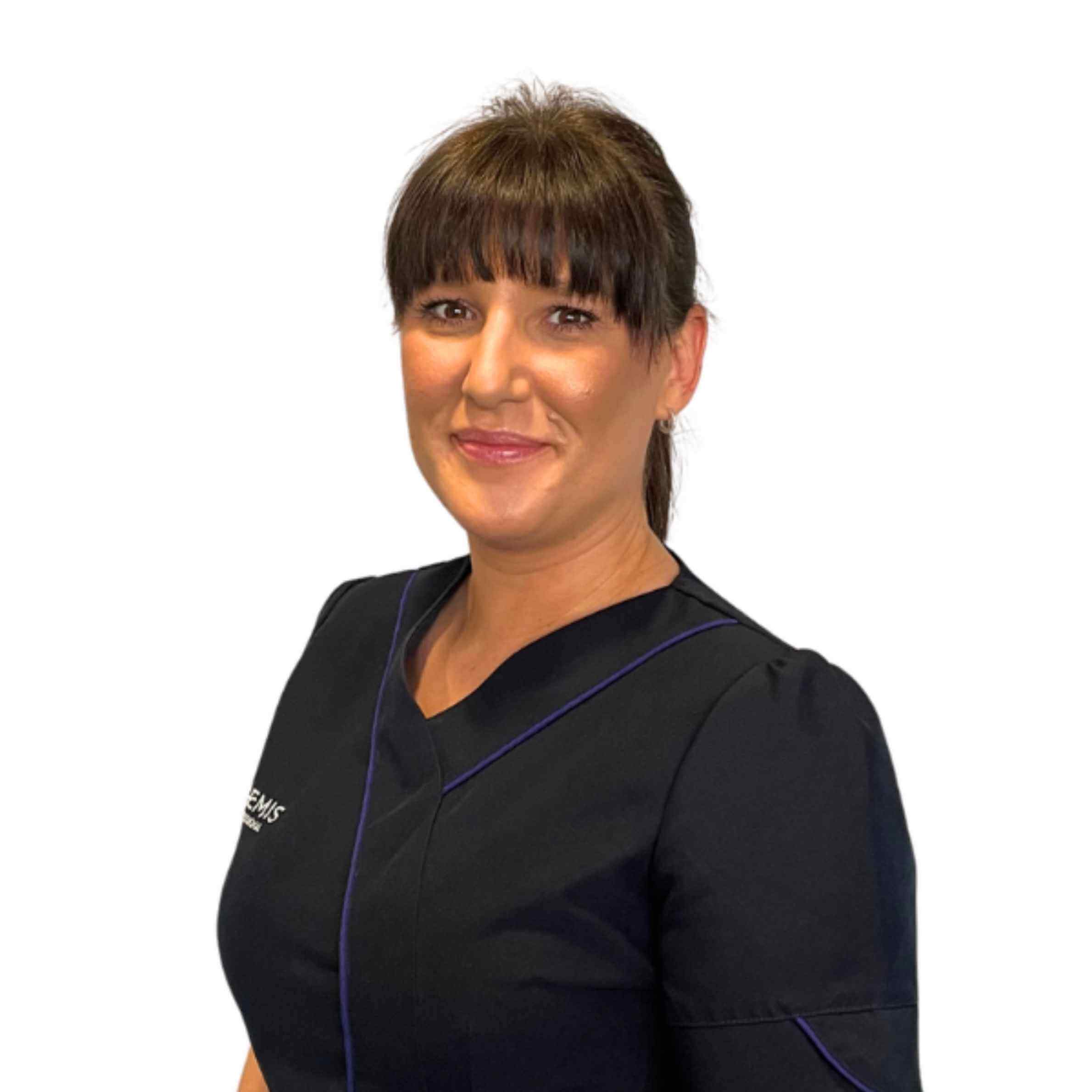 Woman wearing a black scrub top with a logo on a white background