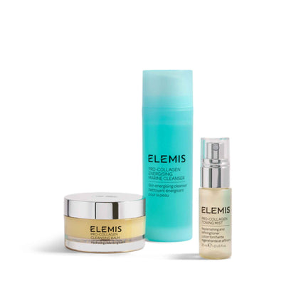 Three Elemis skincare products arranged on a white background: a clear jar with pale yellow cream and a silver lid, a tall translucent aqua bottle, and a small clear bottle with a silver spray top.